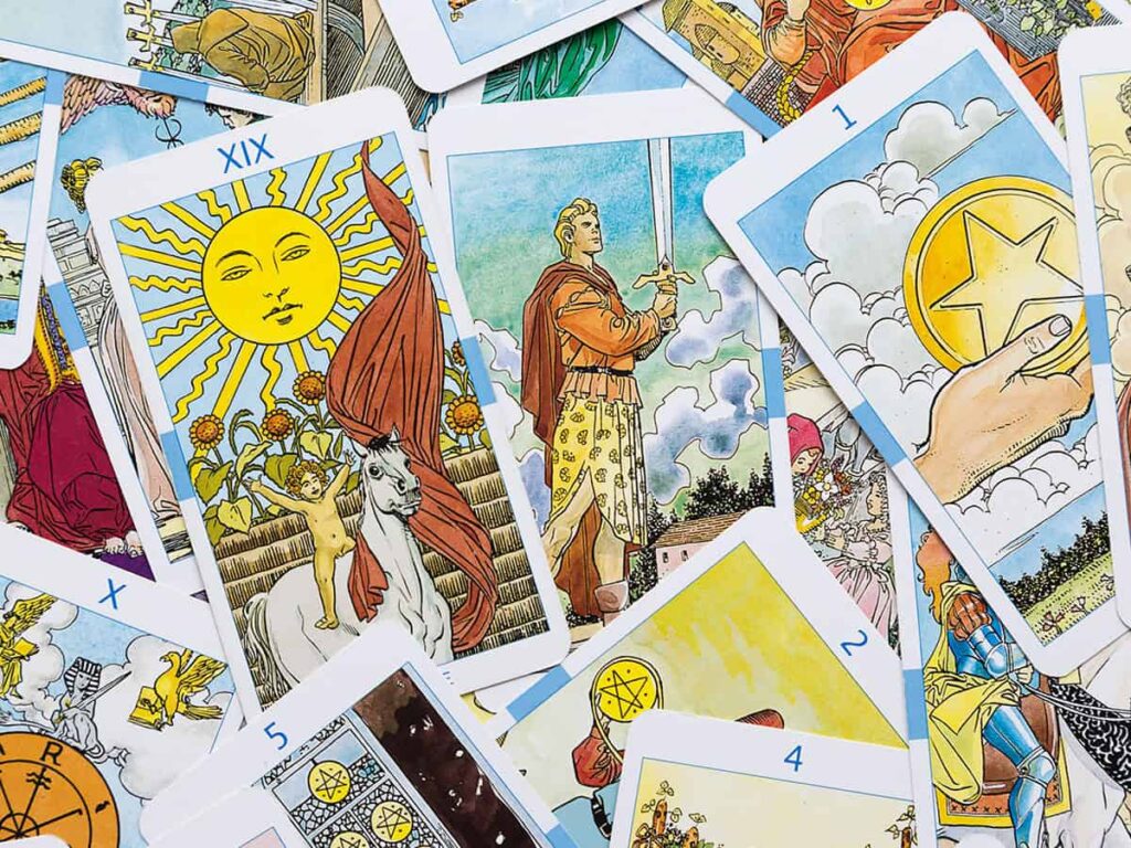 Bu görselde masanın üzerine saçılmış tarot kartları yer alıyor.